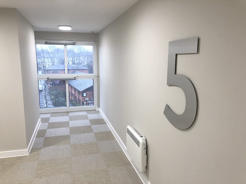 Large number five sign in brushed stainless steel, denoting the floor level in Brook Place Apartments